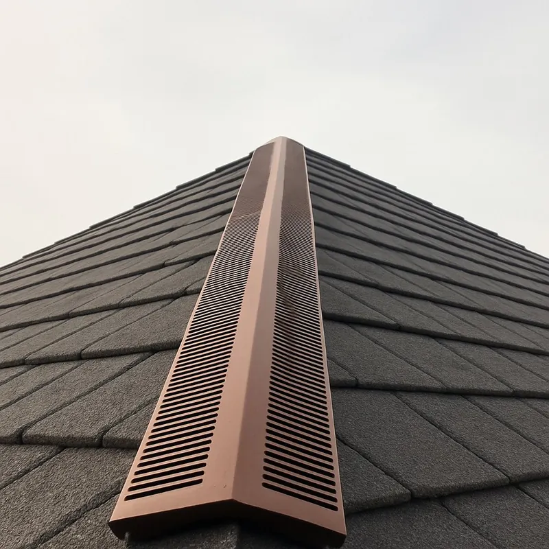 Faîtage ventilé posé sur closoir au sommet d'un toit en tuiles anthracite
